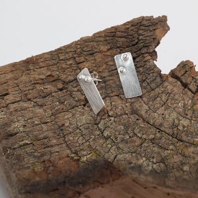 Pendientes Xirimiri medianos de Emeki Joyas, joyería artesanal en plata de ley con gotas situadas en la parte superior, diseño geométrico y contemporáneo.